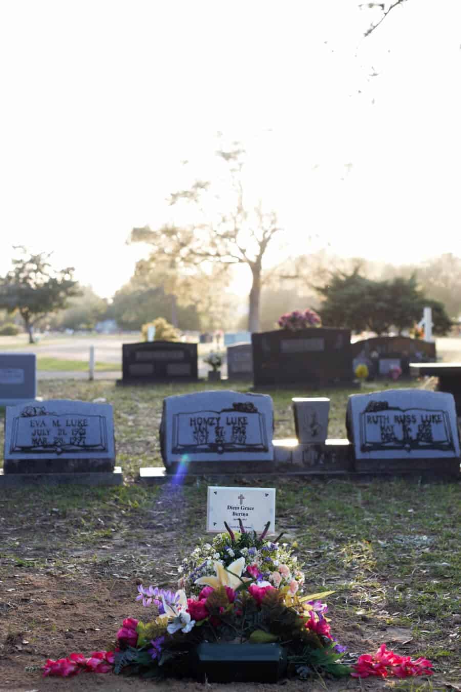 Baby Headstone the day she was buried with flowrs on the grave. Older headstones are behind her marker.