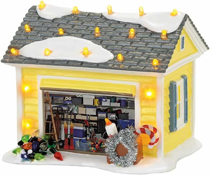 Tiny yellow holiday decorated house with lights and ornaments, festive holiday decor, Christmas scene, white snow accents, storage garage model.