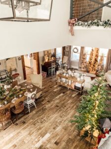 Cozy holiday decorated living room with Christmas trees and festive decor, creating a warm and inviting atmosphere.