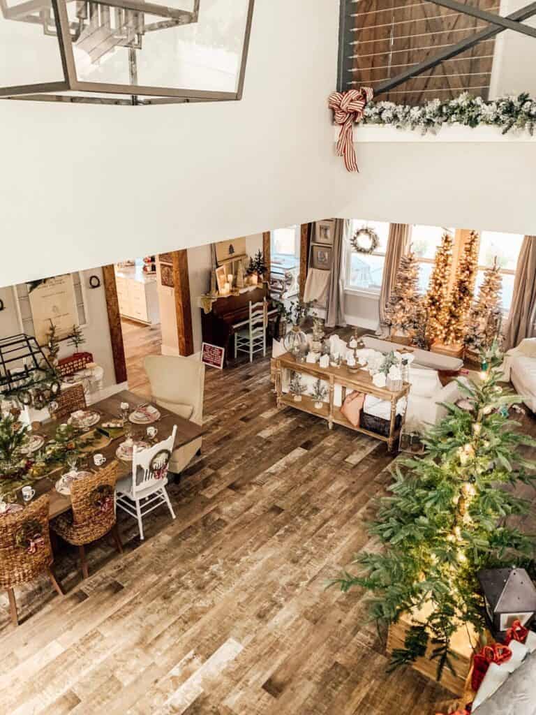 Cozy holiday decorated living room with Christmas trees and festive decor, creating a warm and inviting atmosphere.