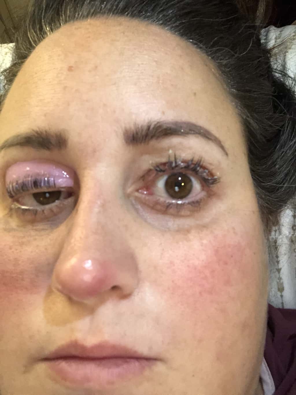 Women with eye open and gobs of gunk on her eyelashes they do appear to be curled up.