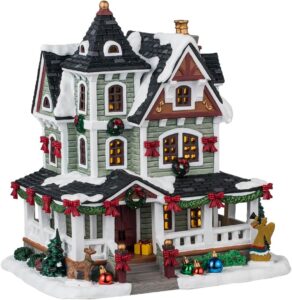 Ornamental Christmas house with festive decorations and snow accents, ideal for holiday decor and collectible displays.
