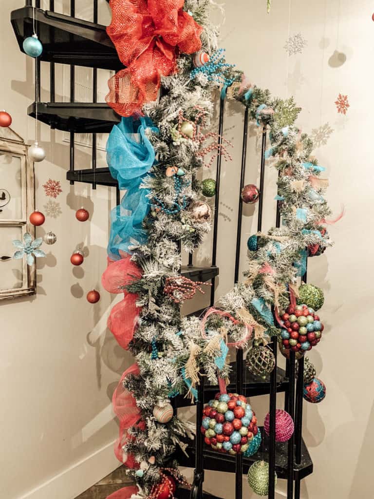 Black Spiral Staircase Wrapped in Garland with Pink and Blue Decor