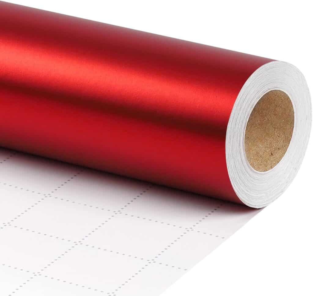 Red heat transfer vinyl roll on cutting mat, ideal for custom apparel and craft projects.