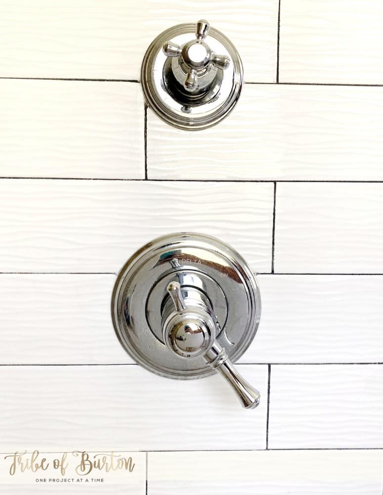 Grey grout lines on white tile of bathroom shower.