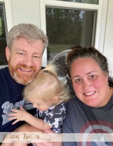 Man and Women with a child sitting on the back porch after exercising. 