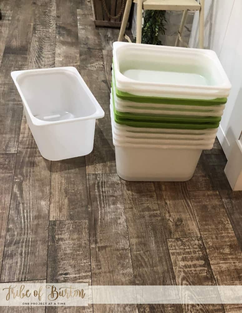 Clear and Bright green plastic buckets stacked on a wooden fllor