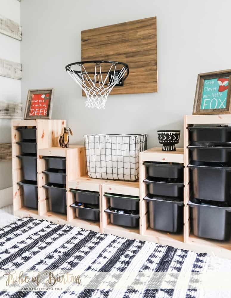 Black Plastic Toy Storage bins on a wooden shelf with a basketball hoop and a black and white rug