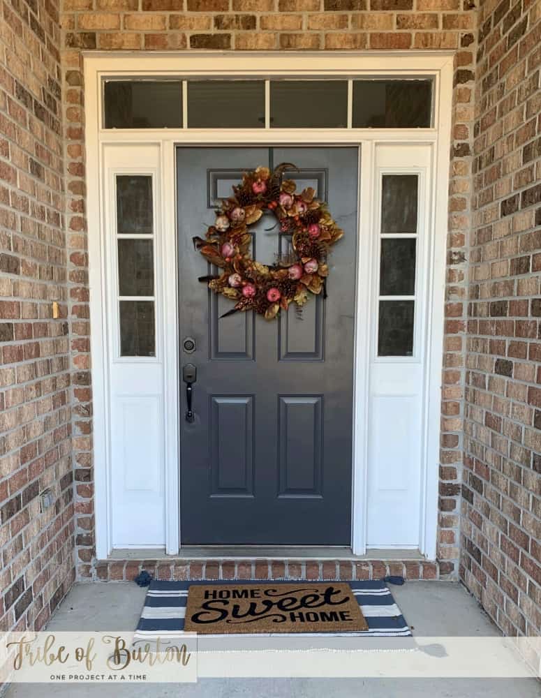 Front door painted dark gray with a fall wreath on it.