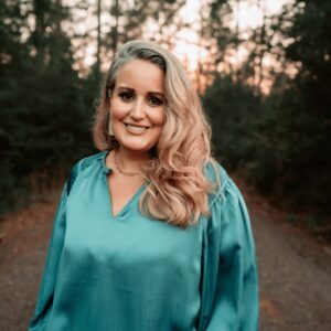 Beautiful woman smiling outdoors in forest setting for Tribe of Burton branding in the outdoor adventure and lifestyle niche.