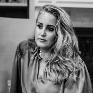 Young woman with wavy hair in a professional setting, representing the Tribe of Burton community.