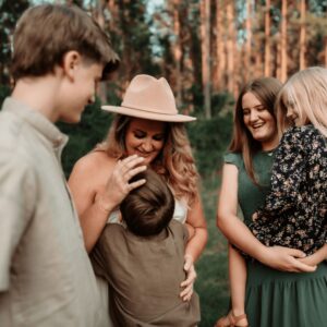 Family enjoying outdoor picnic together in forest, smiling, hugging, having fun, beautiful natural scenery, lifestyle, togetherness, happiness, bonding, outdoor activity, nature, friends, celebrating, leisure, relaxing, summer, outdoor adventure, family gathering, life moments, friendship, warmth, bonding moments, natural environment, happy moments.