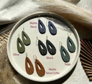 Matte navy and black teardrop earrings display on a white plate for Tribe of Burton jewelry collection.