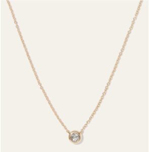 Delicate gold necklace with round diamond pendant, perfect for elegant jewelry styling.