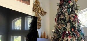 Festive decorated Christmas tree with ribbons, ornaments, and greenery in a holiday home interior.