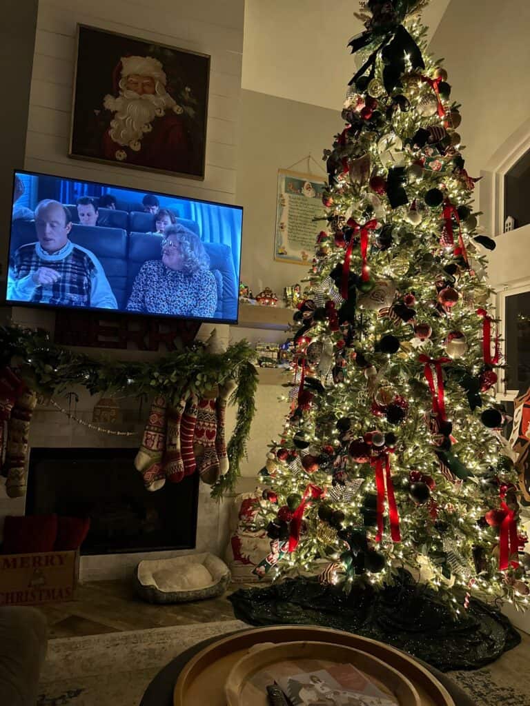Festive Christmas living room decorated with a beautifully lit Christmas tree, stockings, and holiday ornaments.