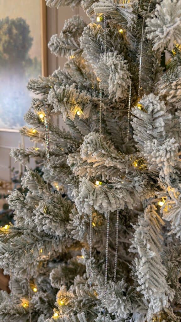 Close-up of snowy flocked branches and warm white LED lights on the King of Christmas Prince Flock tree
